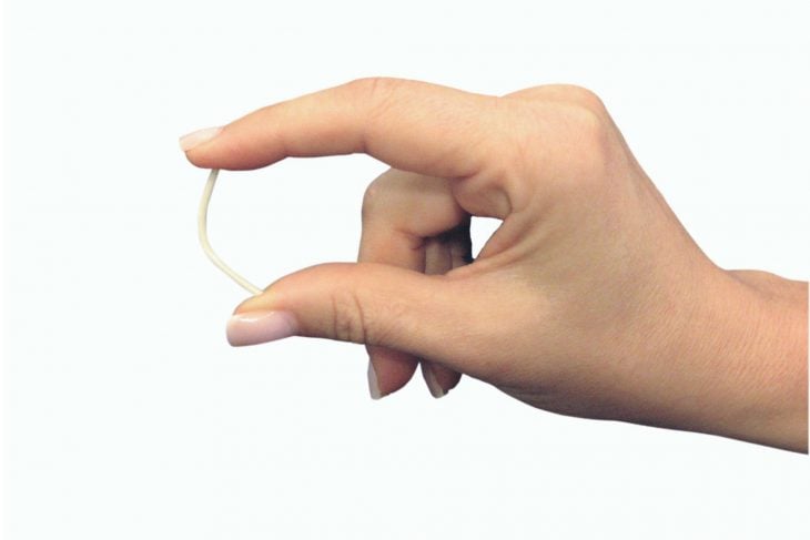 Mano de mujer midiendo implante anticonceptivo
