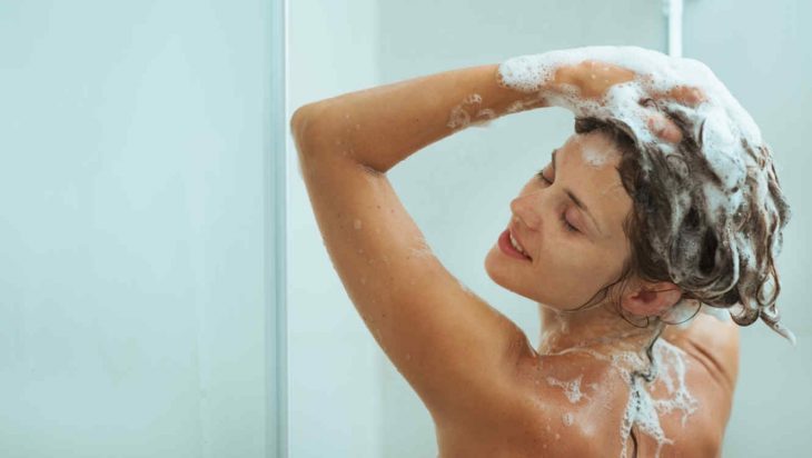 Mujer en la regadera lavándose el cabello