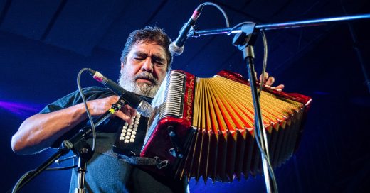 Celso Piña tocando acordeón en un escenario