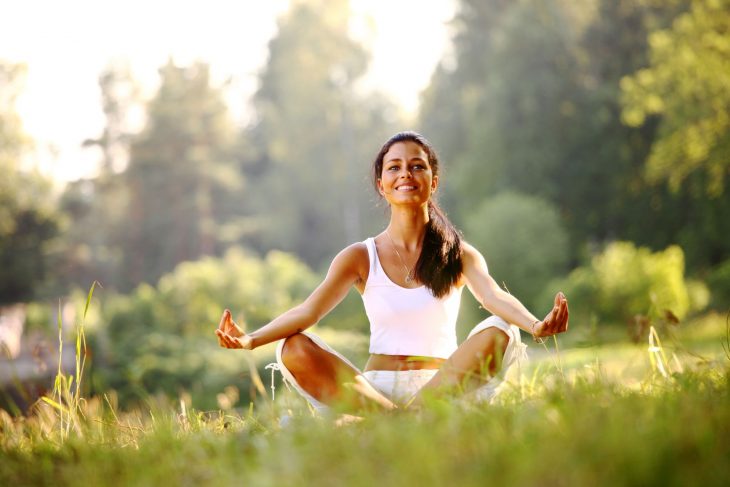 Mujer meditando en un campo