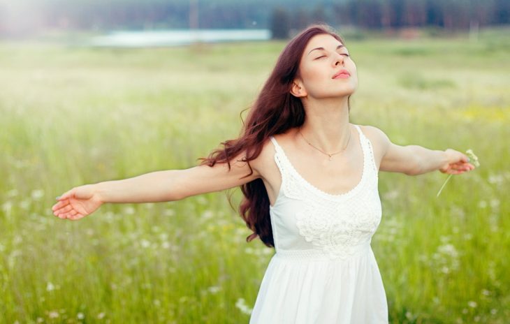 Mujer abriendo sus brazos y respirando profundamente