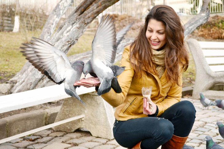 Mujer alimentando a las palomas