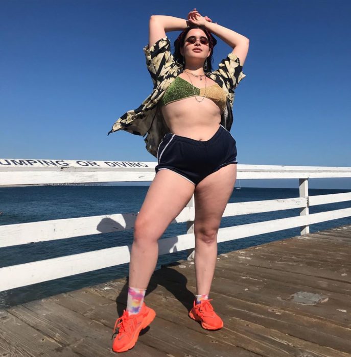 Barbie Ferreira en un muelle con short y una blusa abierta