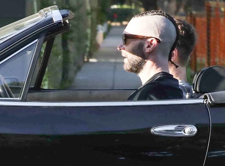 Adam Levine conduciendo un auto deportivo con quema cocos