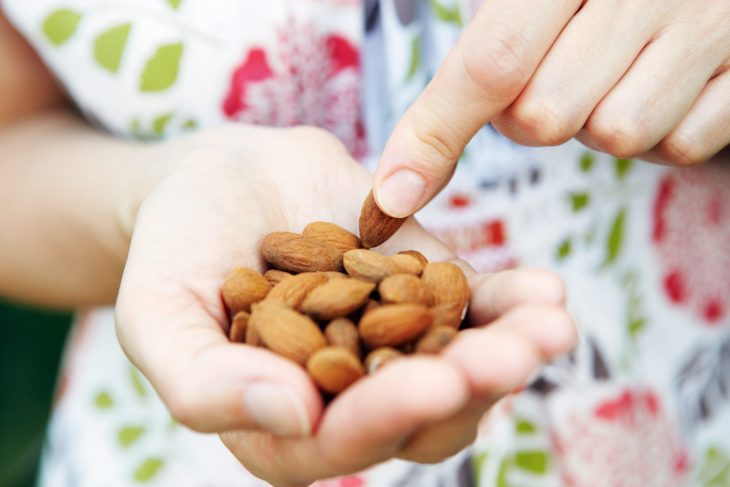 Mano de mujer sosteniendo almendras