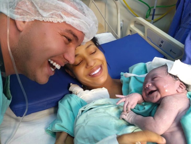 Flavio y Tarsila Vilela con su hija recién nacida que sonríe 