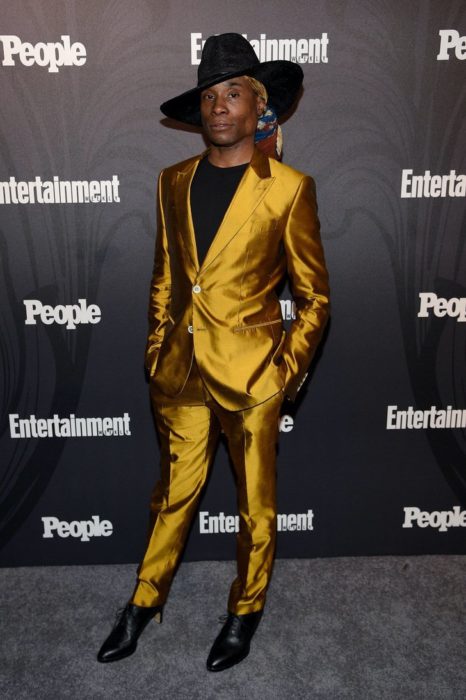 Billy Porter con traje amarillo y tacones negros