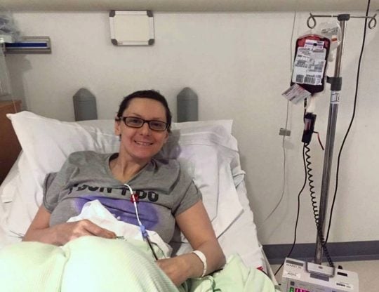 Emma Burrows acostada en una cama de hospital conectada a una bolsa de suero