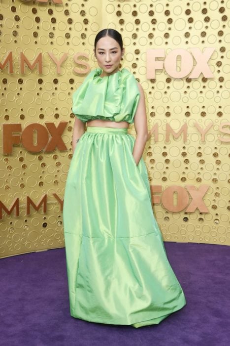 Greta lee usando un vestido verde de dos piezas para los emmy 2019