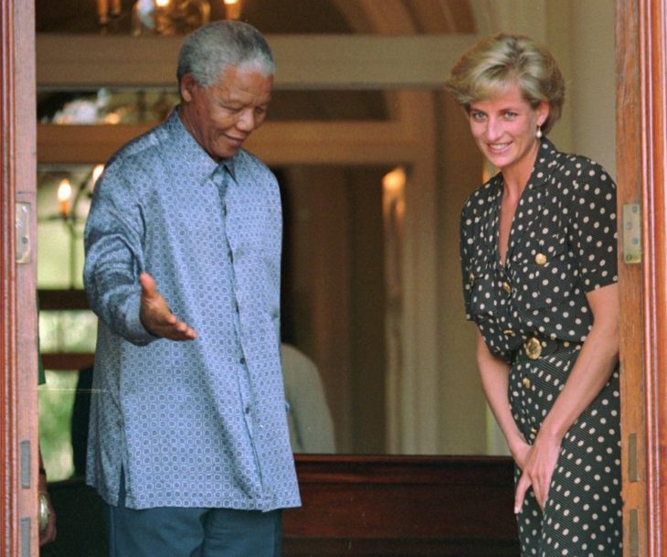 Diana de Gales con Nelson Mandela quien hace una señal de cederle el paso