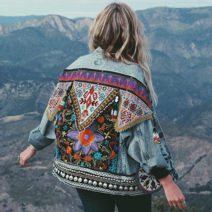 Ropa estilo boho o hippie chic; mujer en las montañas con chamarra de mezclilla con tejido indígena