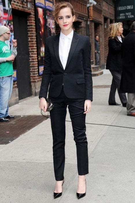 Famosas con traje; Emma Watson en la calle con saco y pantalón de vestir, zapatillas, bolsa de mano y el cabello recogido en una cola de caballo