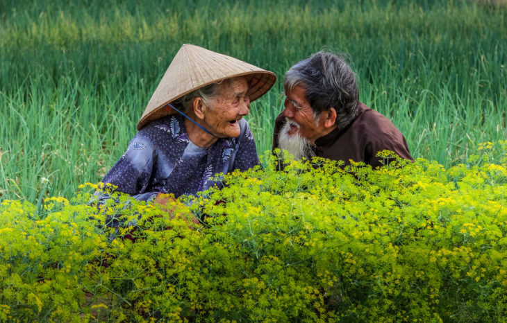 Pareja de ancianos viéndose mientras están en medio del campo 