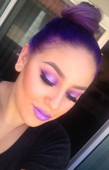 Chica usando un maquillaje monocromático de color morado en ojos y labios 