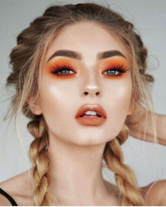 Chica con un maquillaje monocromático en ojos y labios de color naranja 