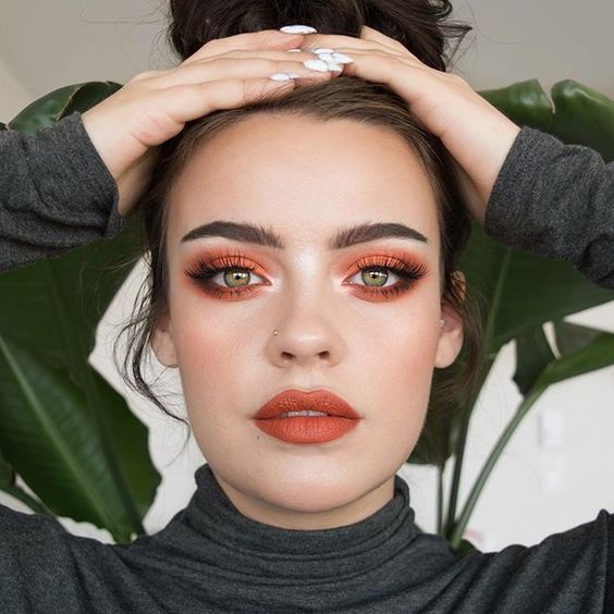 Chica usando un maquillaje monocromático de tonos tierra naranja 