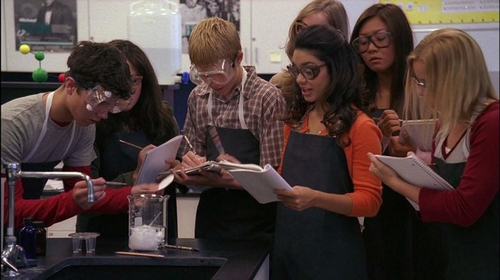 un grupo de estudiantes en un laboratorio con mandiles y lentes de protección