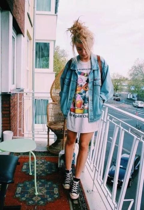 Chica en un balcón llevando camisa larga con estampado de dibujos animados