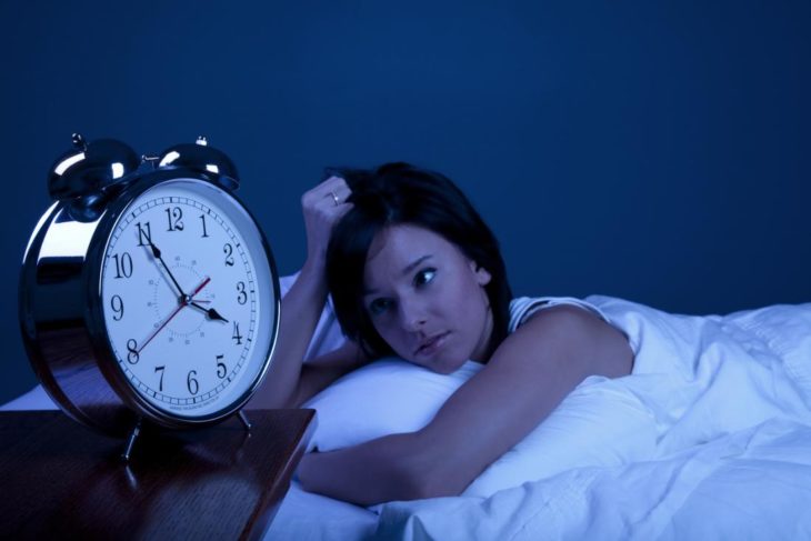 Mujer que no puede dormir viendo el reloj