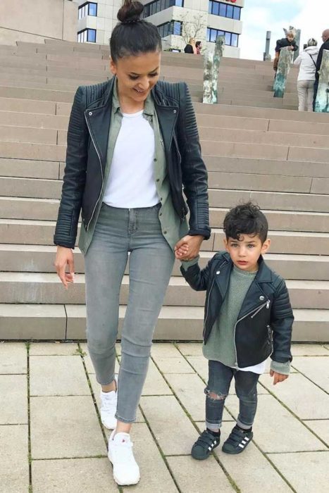 Madre e hijo usando jeans de mezclilla, chaqueta de cuero y camisas lisas