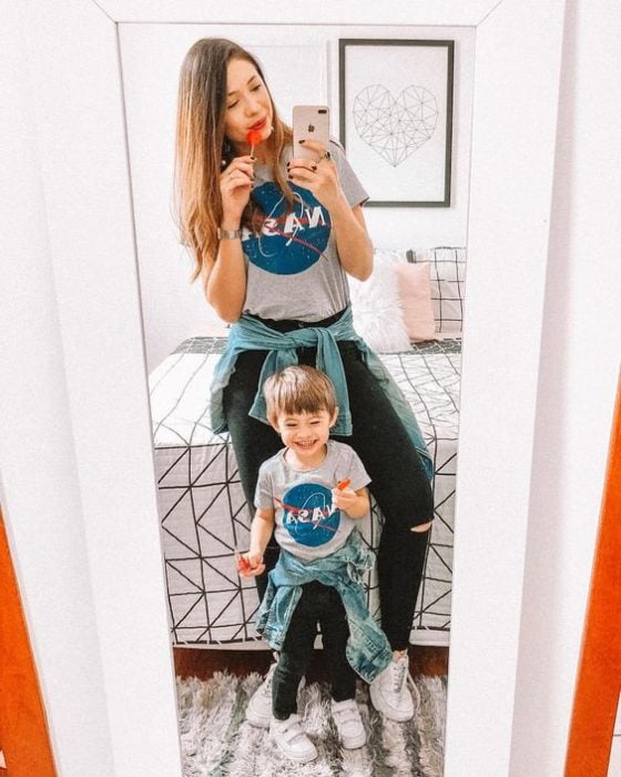 Madre e hijo frente al espejo tomando una selfie, mostrando sus outfits a juego con playeras de la NASA