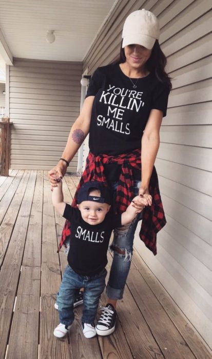 Madre e hijo usando playeras oscuras con jeans negros y cachuchas oscuras 