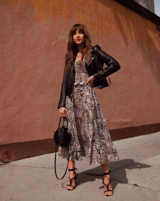 Outfits para otoño; chica con vestido de animal print y chaqueta de cuero negra, con sandalias de tacón