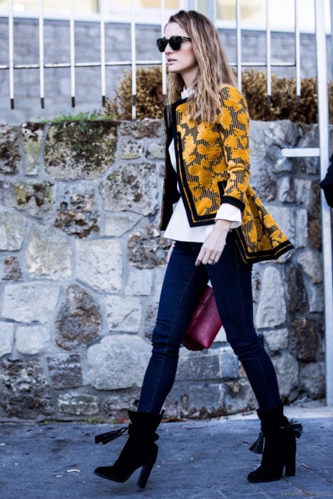 Outfits para otoño; mujer de cabello rubio balayage, con saco floreado amarillo, jeans y botines negros