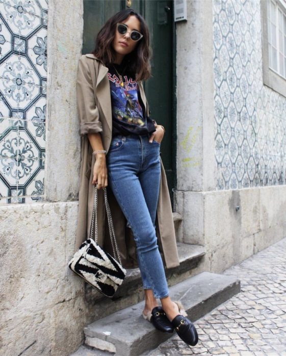 Outfits para otoño; foto de chica en escaleras, con camisa de bandas de rock, mom jean y saco largo caqui