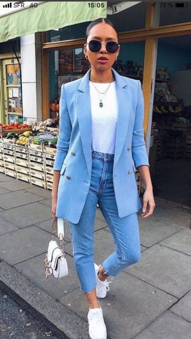 Chica usando jeans apretados, tenis y saco de color azul 