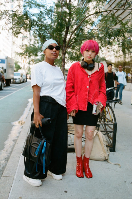 Estudiantes de Parsons y New School muestran sus atuendos para su primer día de clases; amigas, chica morena y chica asiática en la calle con ropa a la moda