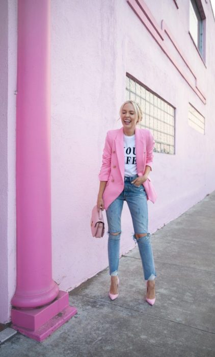 Chica usando unos jeans con blusa blanca y blazer de color rosa 