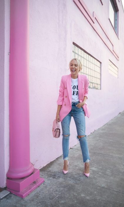 Chica usando unos jeans con blusa blanca y blazer de color rosa 