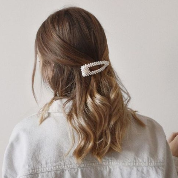 Chica con el cabello hasta el hombro recogido con un broche