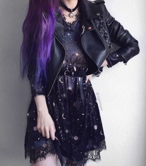 Ropa de constelaciones; mujer de cabello morado y largo, con vestido de universo con lunas y estrellas y tela de encaje, con chamarra de cuero