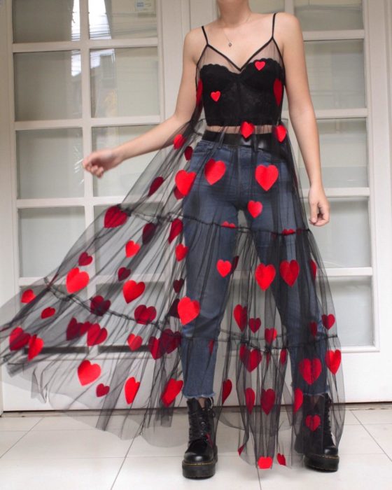 Ropa femenina de Lirika Matoshi; vestido de tela de encaje semitransparente de color negro con corazones rojos, de tirantes y con pantalón de mezclilla y crop top abajo