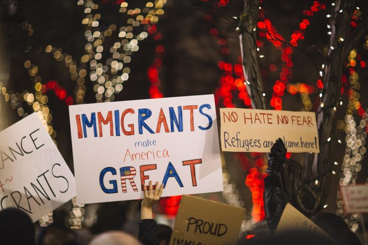 una manifestación pro inmigrantes con carteles que dicen que los inmigrantes harán a America grandiosa otra vez