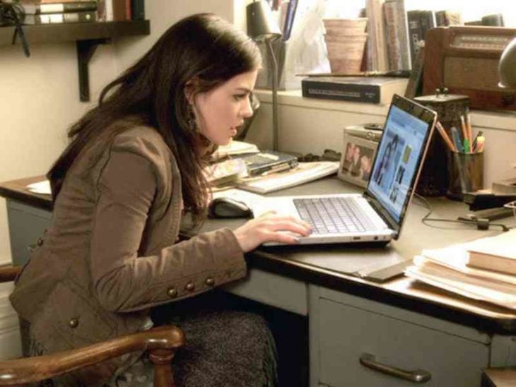 Una mujer ve una fotografía de una pareja en una computadora sobre un escritorio