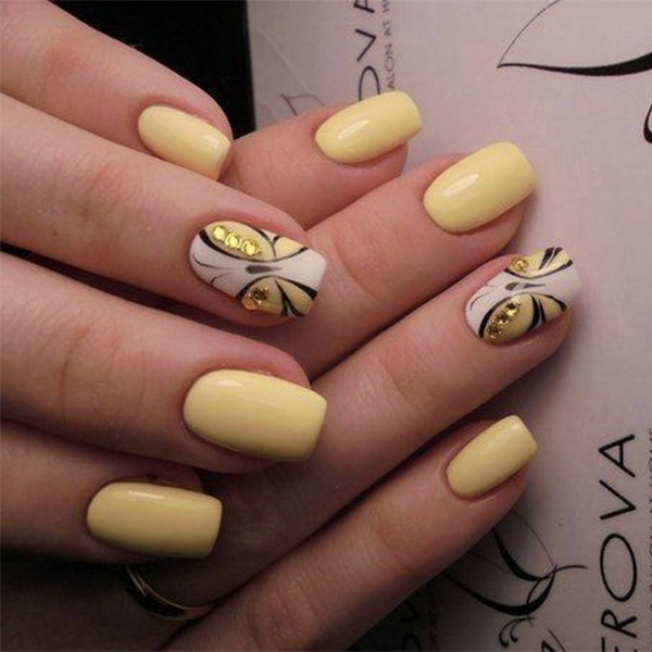 Chica con unas uñas de mariposa en colores amarillos con negro 