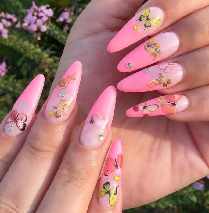 Chica con unas uñas de mariposa en colores rosa pastel y amarillo 