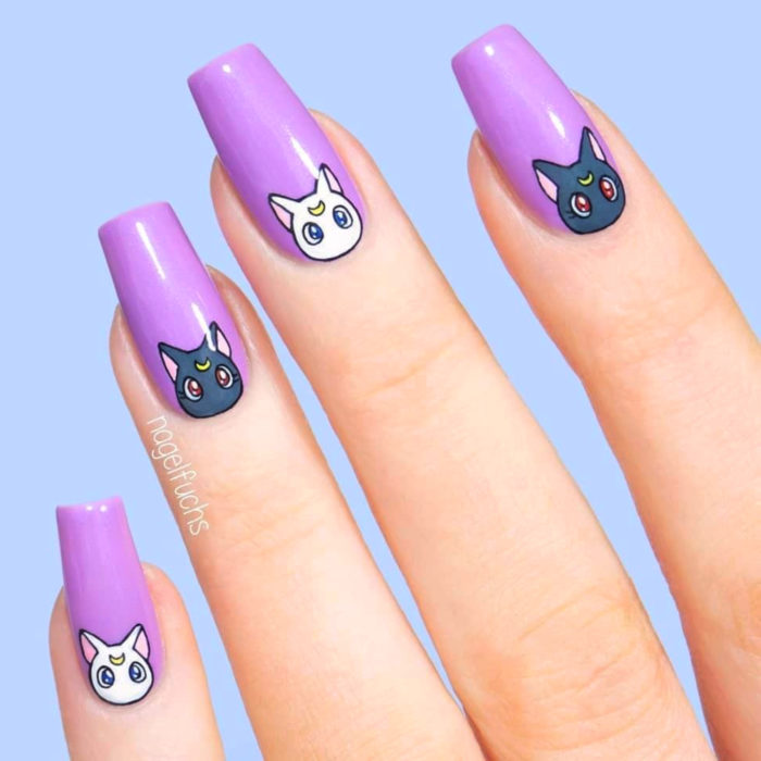 Manicura de Sailor Moon; uñas largas cuadradas pintadas de morado con gatos Luna y Artemis