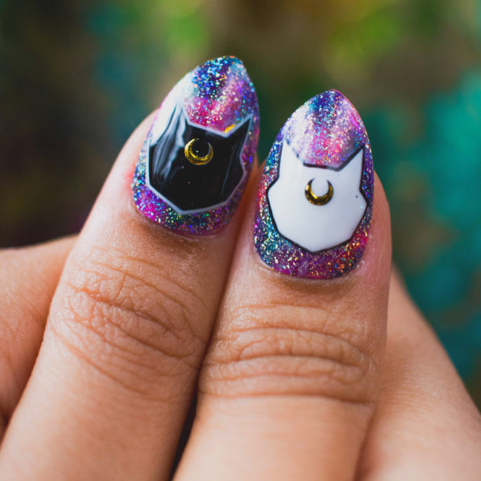 Manicura de Sailor Moon; uñas cortas stiletto pintadas de morado con glitter, con diseño de gatos Luna y Artemis