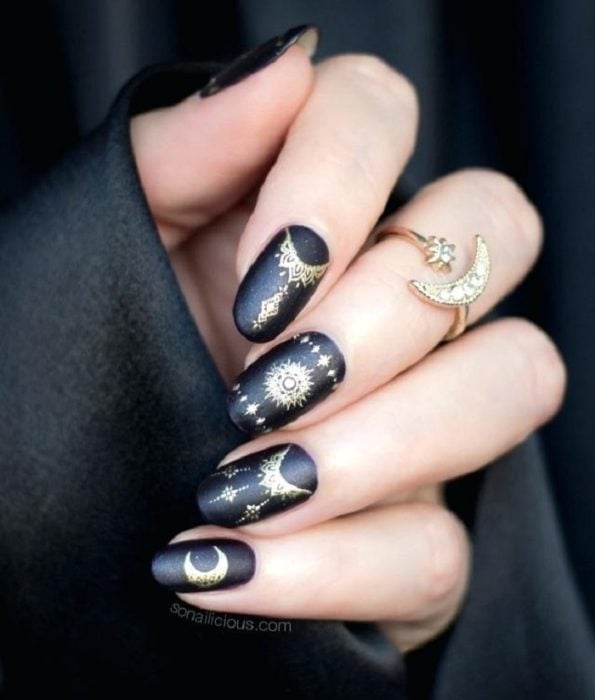 Uñas con manicura estilo bruja para Halloween; negras con detalles dorados