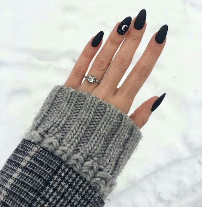 Uñas con manicura estilo bruja para Halloween; negras con una luna pequeña blanca; stiletto