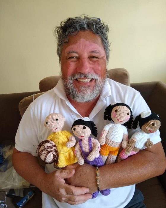 Joao Stanganelli sosteniendo a cuatro muñecas