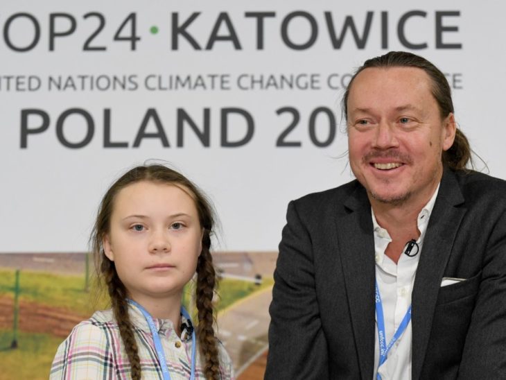 Greta Thunberg con su padre con una lona de fondo de un evento de la ONU en Polonia 2018