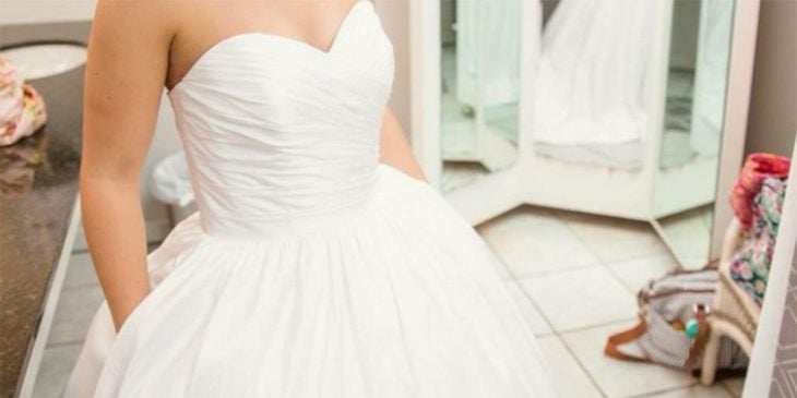 el torso de una mujer con un vestido de novia vaporoso con las manos dentro de los bolsillos laterales del vestido