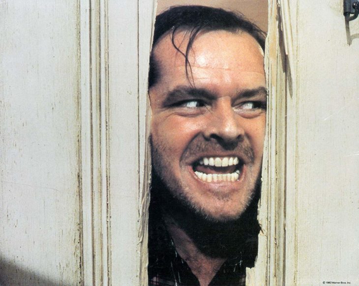 Jack Nicholson en la escena ícono de 'El resplandor' asomando la cara entre la puerta