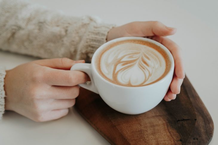 Manos de mujer sosteniendo una taza de café