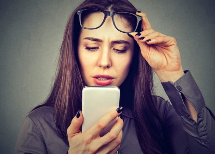 mujer viendo el celular con gesto sorprendido